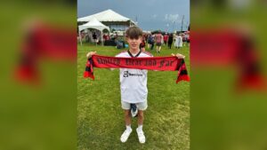 Will Parsons holding a soccer scarf at a 2026 World Cup match — a story about repetition, the wall, and the SAT